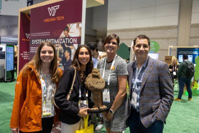 A group photo at Pack Expo in Chicago on the showroom floor with a corrugated Hokie Bird.