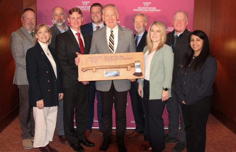 Paul Winistorfer holding a commemorative ax flanked by the CNRE leadership team