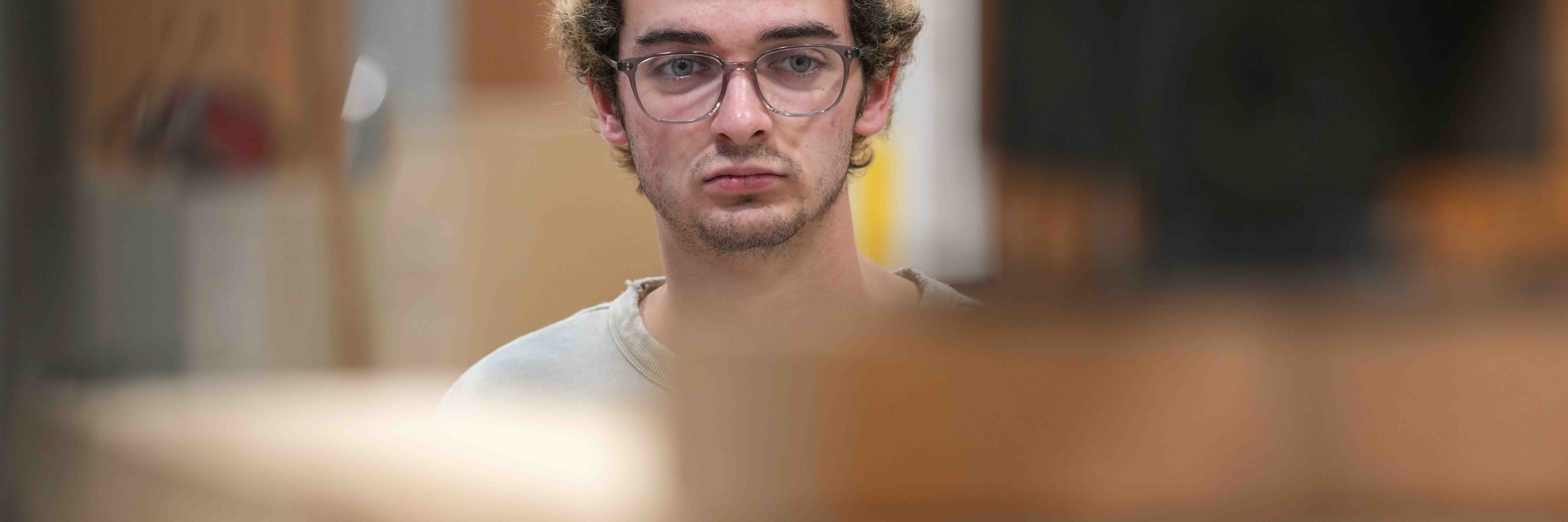 A student researcher watches a load test being performed on cross-laminated timber