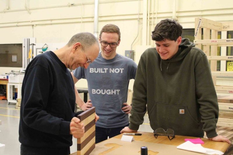 WEI 2019-2020 team members Robert Egan and Tobi Troyer facing a quality review of their prototype cutting board by instructor Urs Buehlmann.