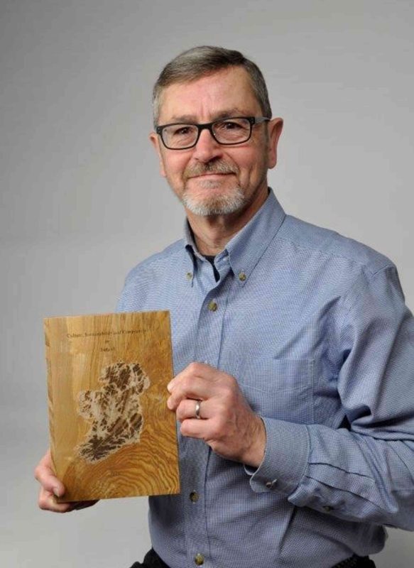 Dr. Robert Bush displays one of a volume of wood “books” produced by students to commemorate their study in Ireland