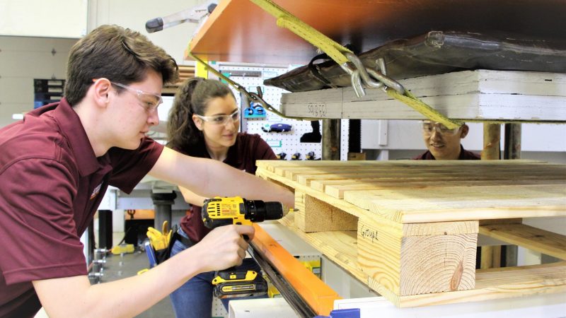 Undergraduate Research Three students setting up a pallet in a test machine