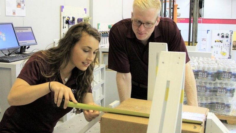 A students measuring a package.